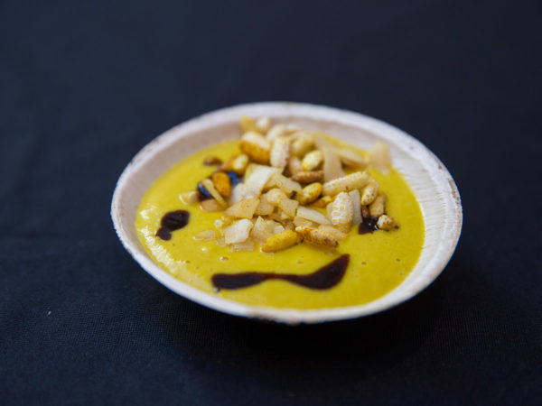A bowl of yellow curry and garnishes